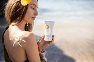 Woman with sunscreen lotion on the beach